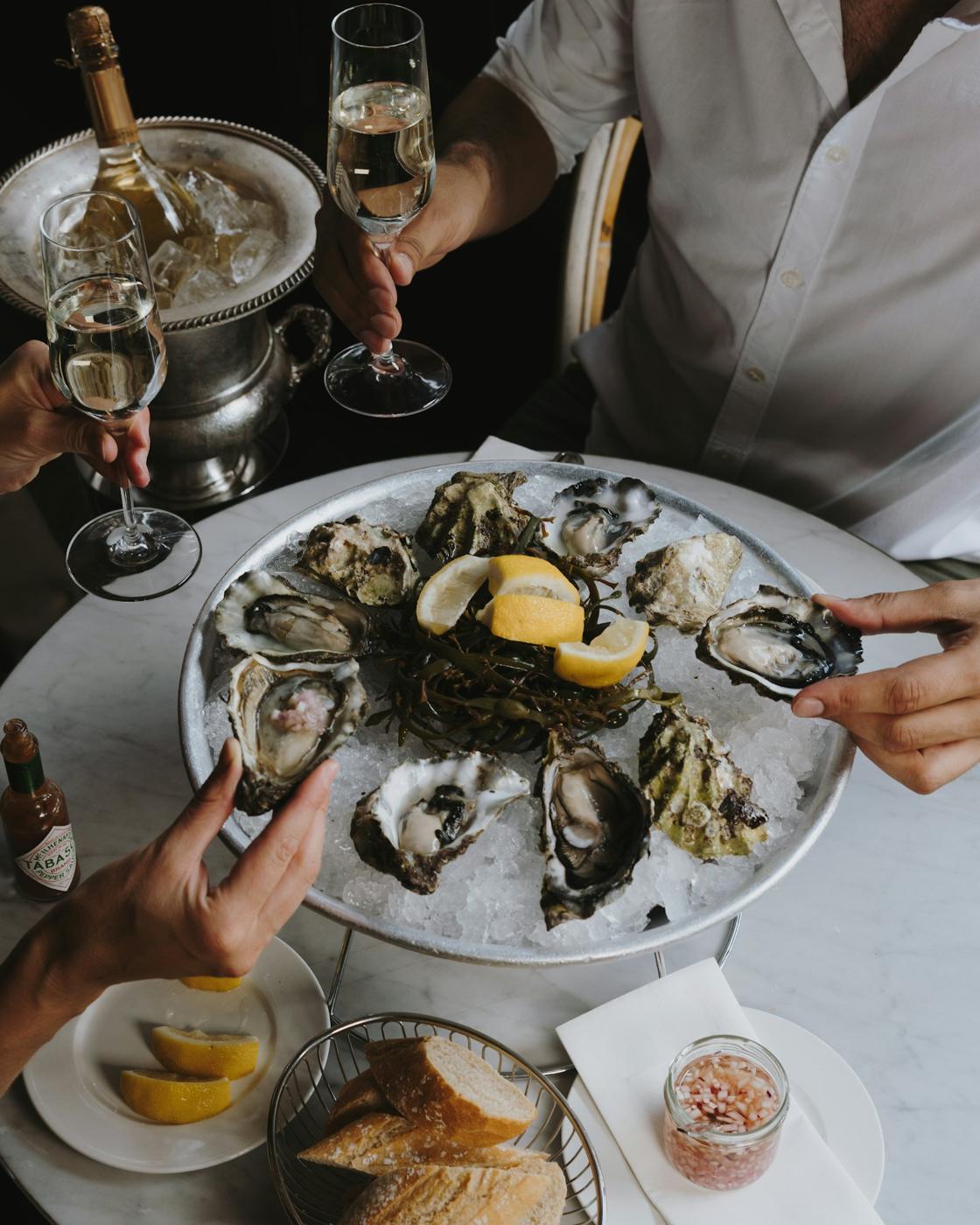 Plateau d'huîtres partagé avec des coupes de champagne
