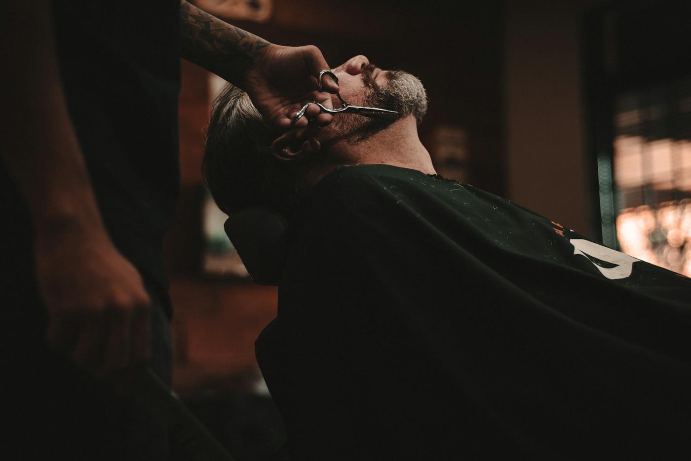 Client renversé dans le fauteuil pendant un rasage