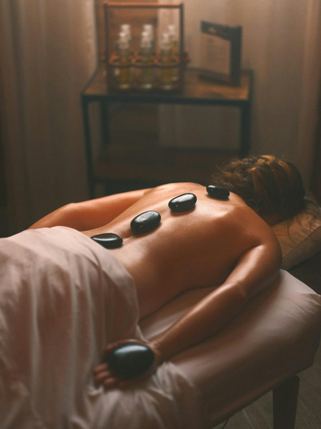 Massage aux pierres chaudes dans une cabine tamisée