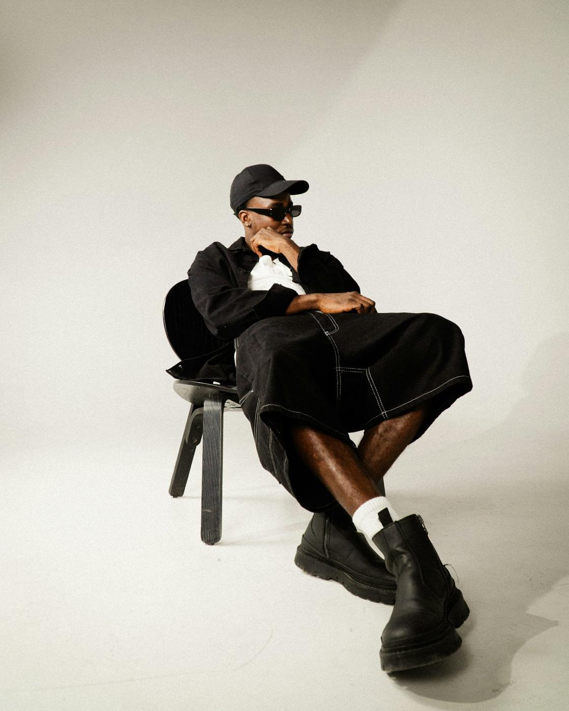 Homme en ensemble noir assis sur une chaise