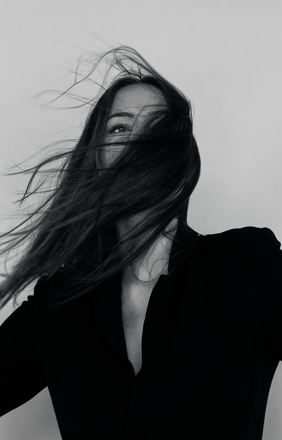 Femme en chemise noire, cheveux au vent